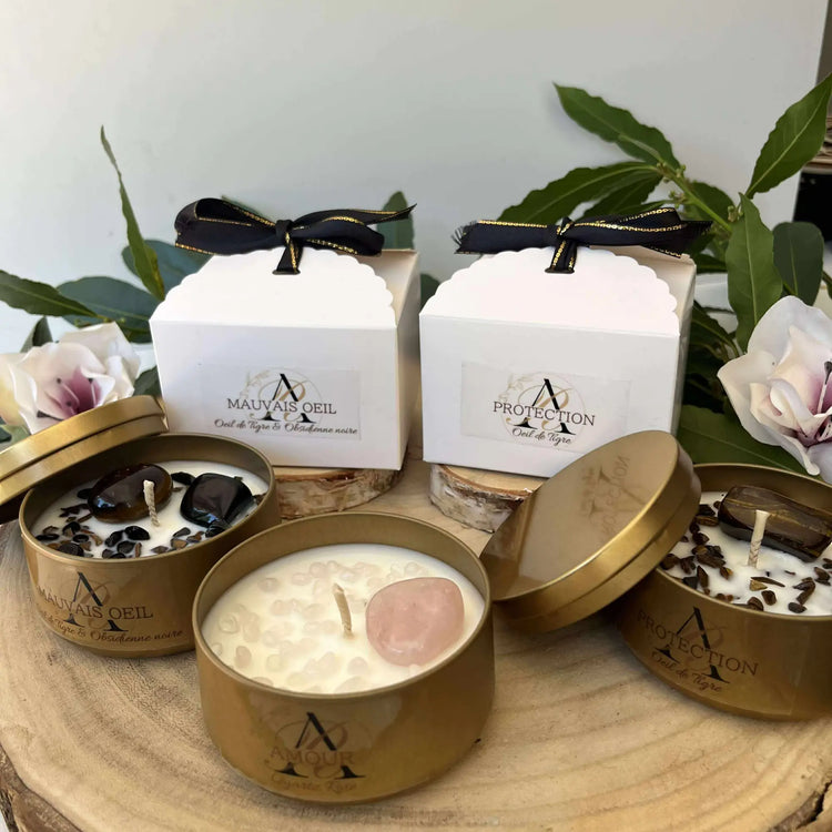 Collection de bougies artisanales avec pierres naturelles présentées en boîtes cadeaux et contenants dorés