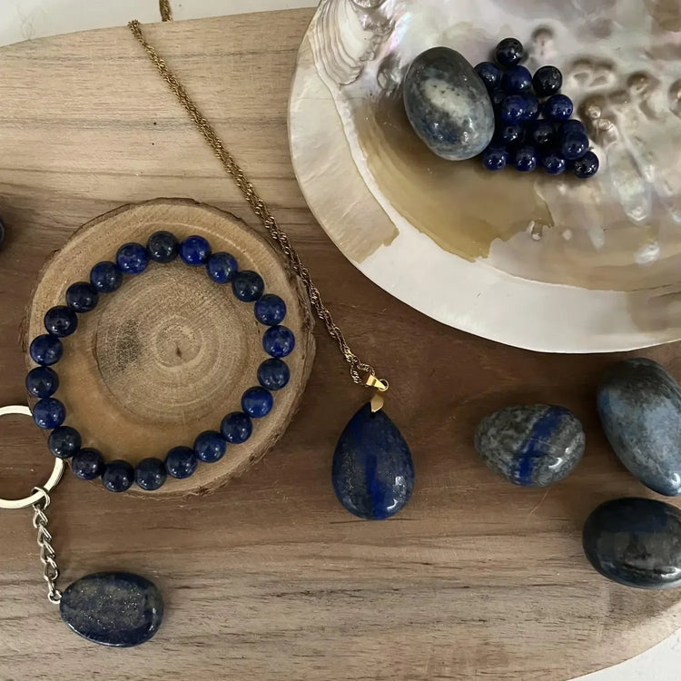Collection Lapis Lazuli Naturelle avec des bijoux en lapis lazuli et des pierres précieuses sur un plateau en bois