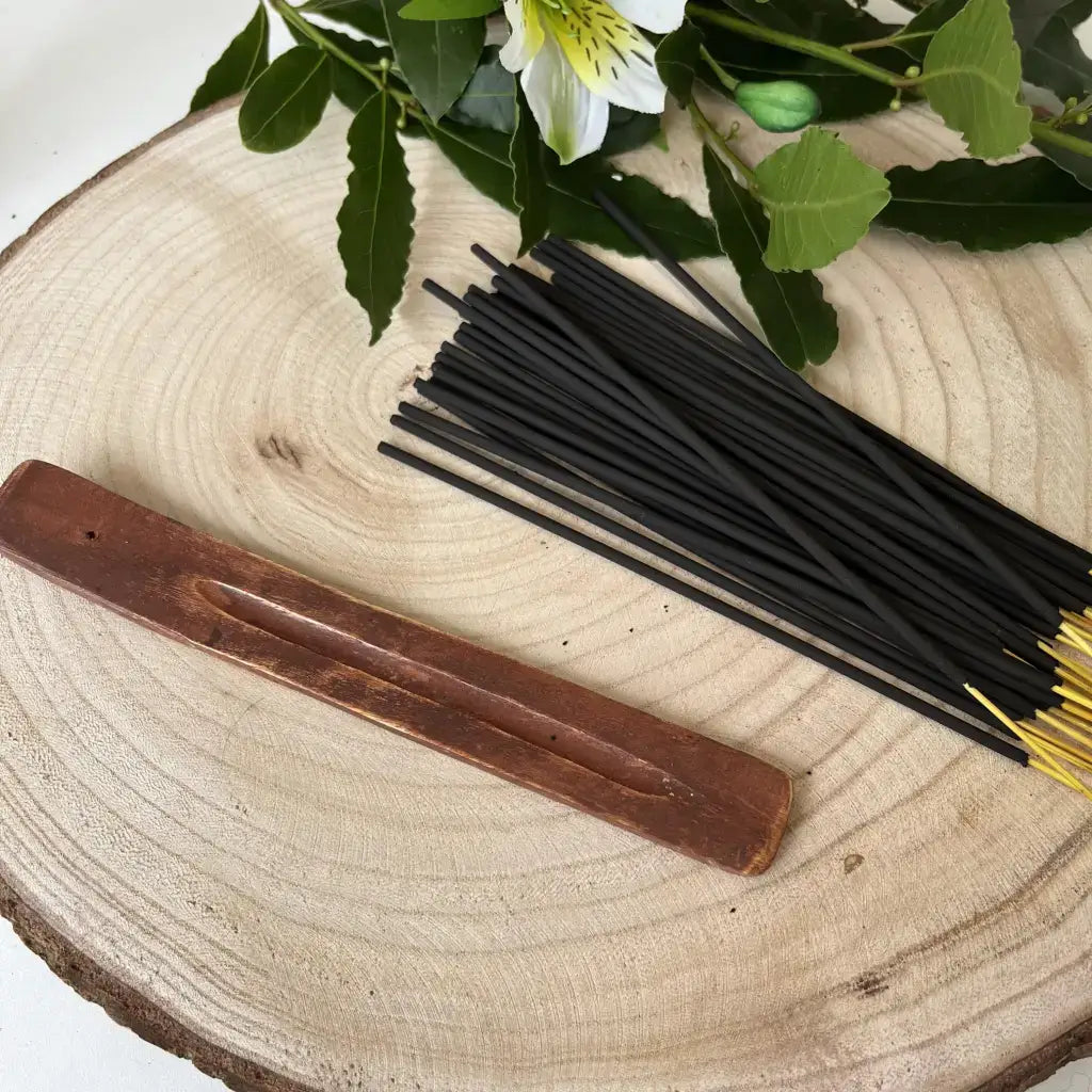 Bâtonnets d'Encens Indiens noirs avec porte-encens en bois sur surface en bois naturel