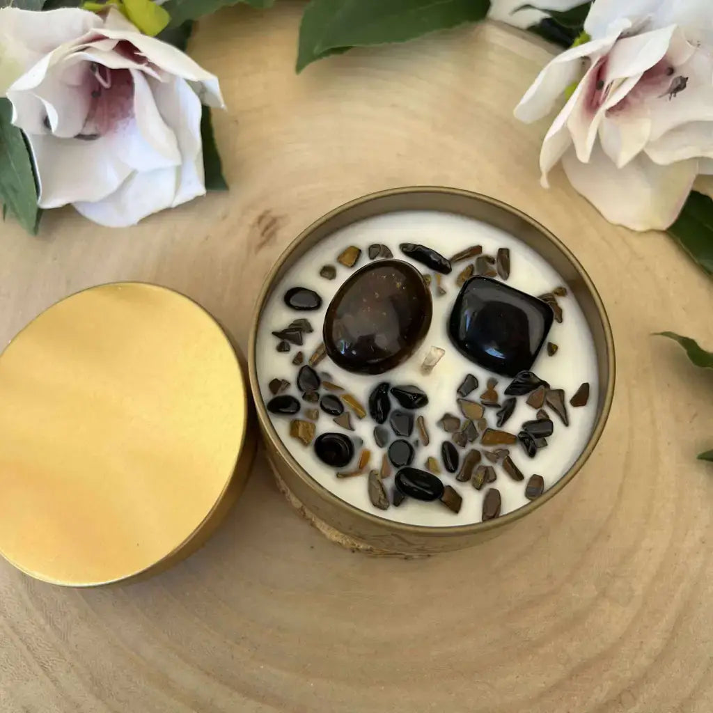 Bougie Mauvais Œil Aura de Roche en boîte dorée avec cire blanche et pierres naturelles brunes et noires