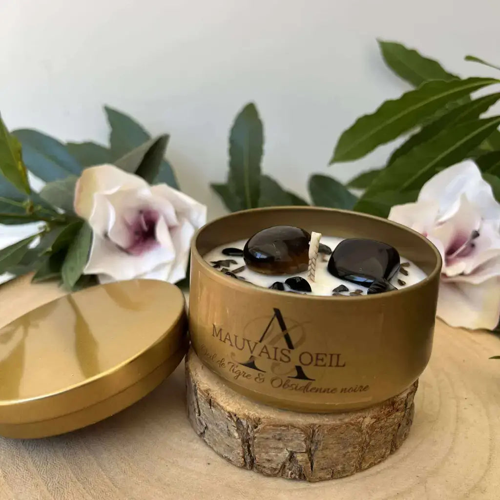 Bougie Mauvais Œil Aura de Roche en boîte dorée avec pierres naturelles noires et fleurs décoratives