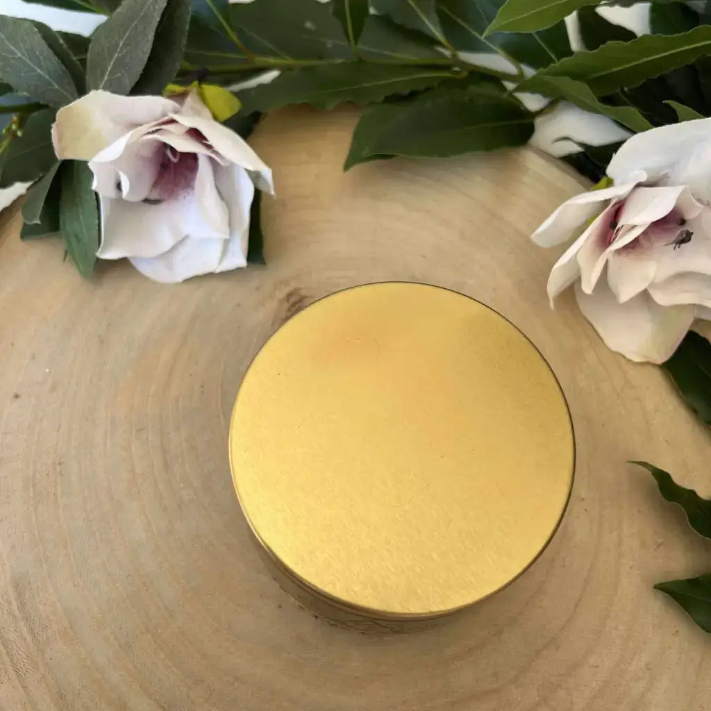 Bougie Protection en Œil de Tigre Aura de Roche dans boîte ronde dorée sur tranche de bois avec fleurs