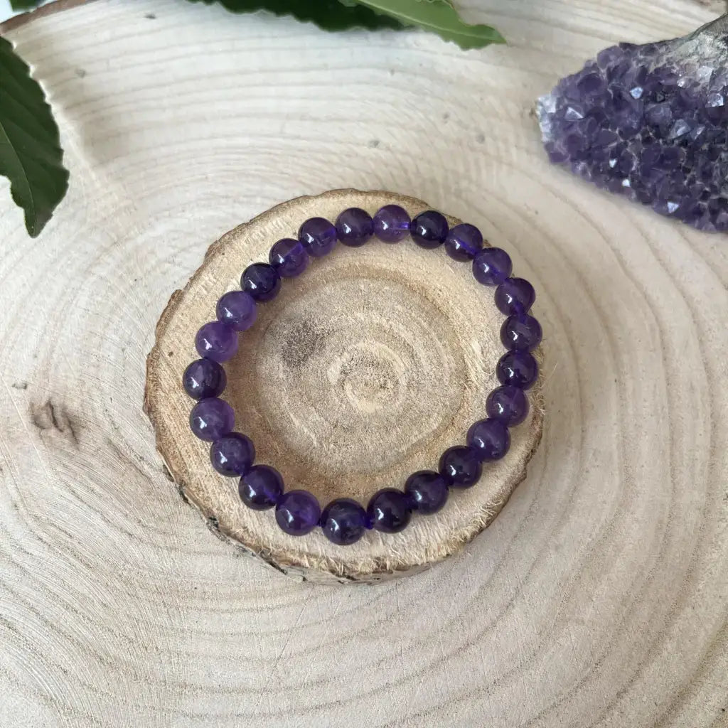 Bracelet Améthyste en perles violettes sur une tranche de bois pour un style naturel