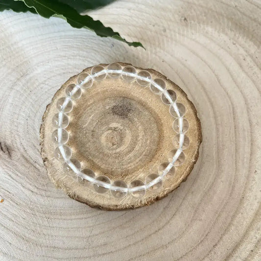 Bracelet Cristal de Roche transparent sur un support en bois naturel pour une touche élégante