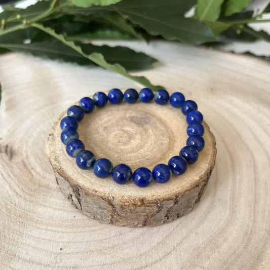Bracelet Lapis Lazuli en perles brillantes sur socle en bois naturel