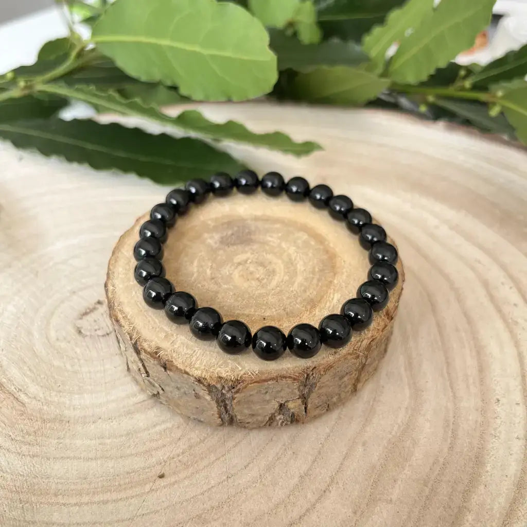 Bracelet Tourmaline Noire en perles semi-précieuses sur un support en bois naturel