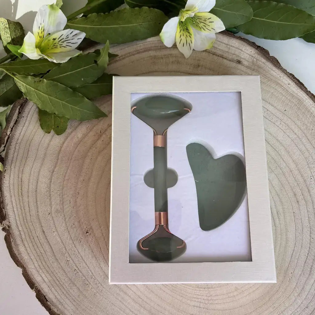Coffret Gua sha et Rouleau de massage Aventurine verte avec détails en rose doré sur fond naturel