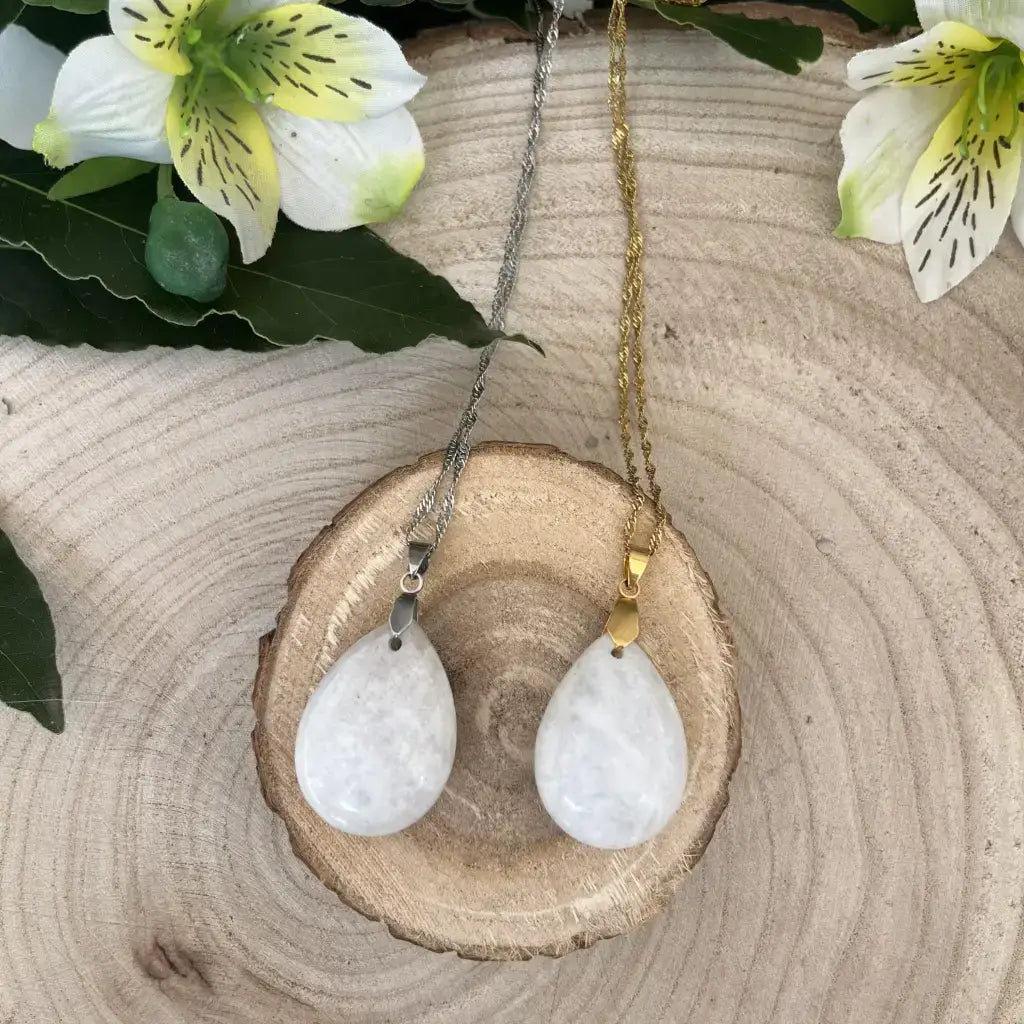 Collier Pierre de Lune Bleutée avec pendentifs élégants en argent et or, présenté sur un support en bois naturel