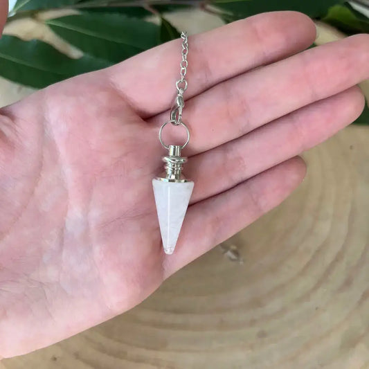 Pendule en Cristal de Roche blanc conique monture argentée sur chaîne, pendule en pierre naturelle tenu dans une main