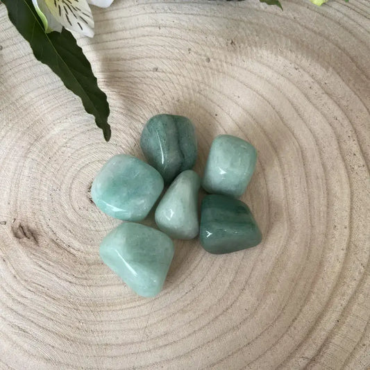 Pierre Roulée Aventurine Verte de Aura de Roche, pierres polies de couleur verte sur un fond en bois