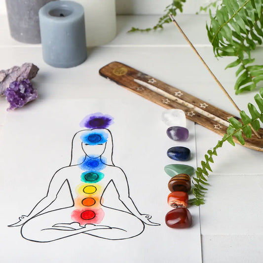 Illustration des chakras et lithothérapie avec un personnage méditant et des pierres de guérison alignées