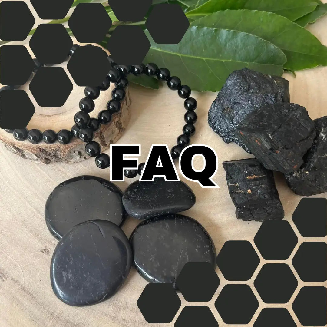 Bracelet et pierres de tourmaline noire naturelle sur une surface en bois avec des feuilles vertes
