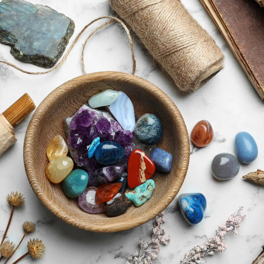 Collection de pierres utilisées en lithothérapie : Comment ça marche, posées dans un bol en bois sur une table.