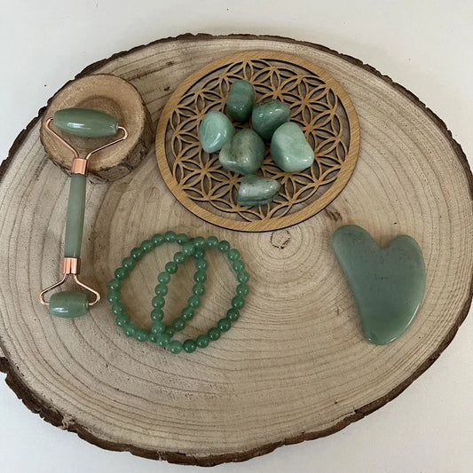 Ensemble de pierre aventurine verte comprenant un rouleau facial et des bracelets sur un plateau en bois