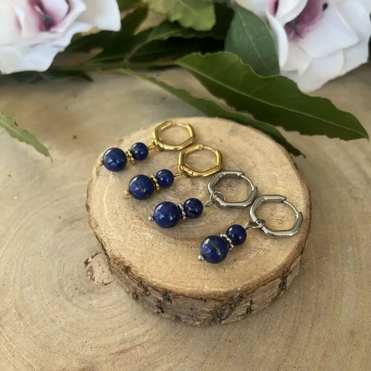 Boucles d'Oreilles Lapis Lazuli en or et argent avec perles brillantes, présentées sur un support en bois