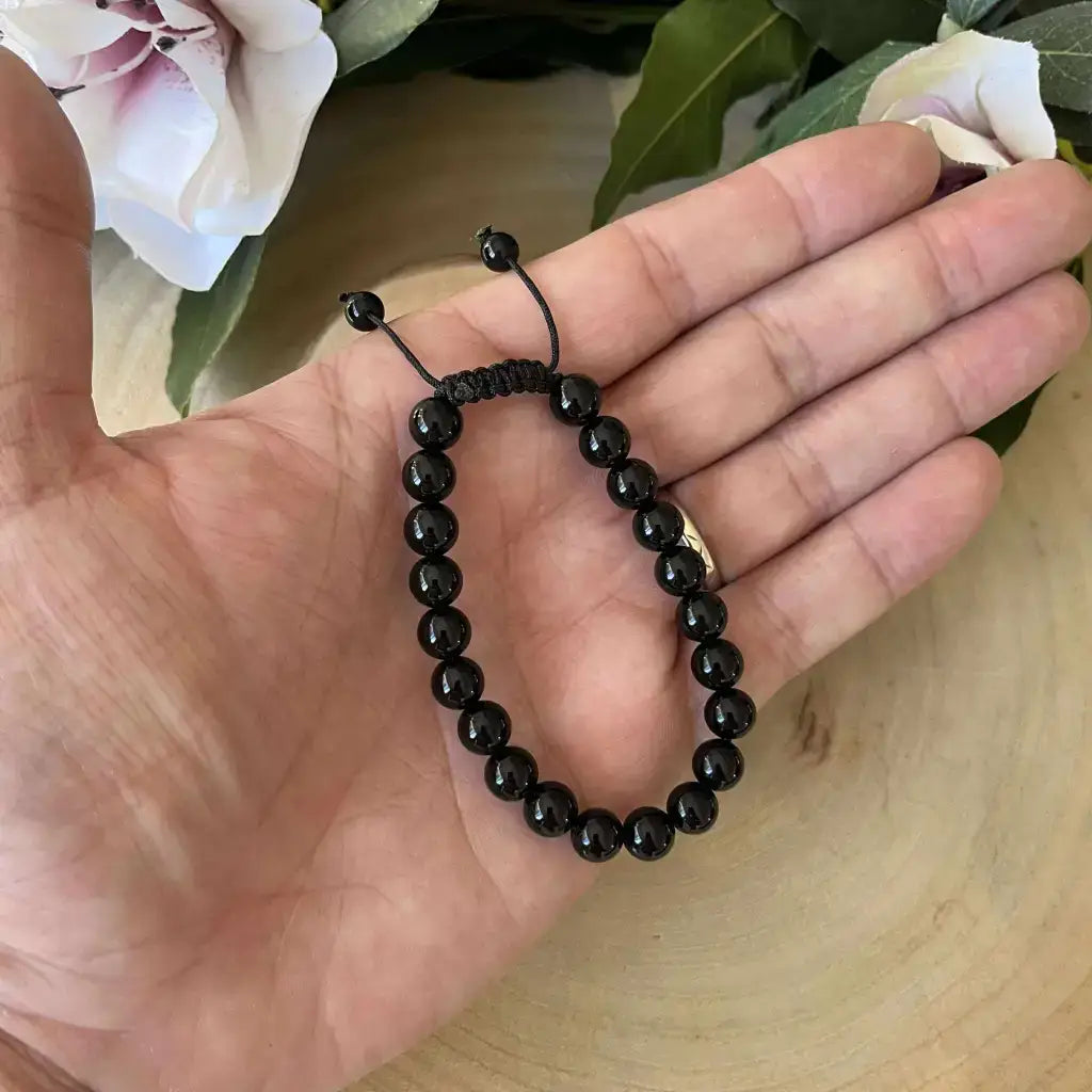 Bracelet Shambala Obsidienne Noire en pierre naturelle sur une main avec cordon ajustable