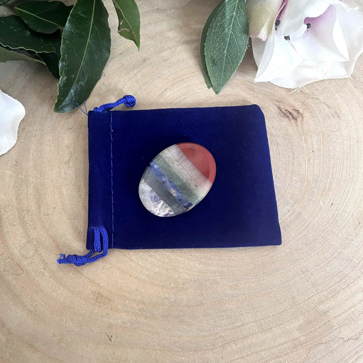 Galet anti-stress 7 chakras posé sur son pochon bleu